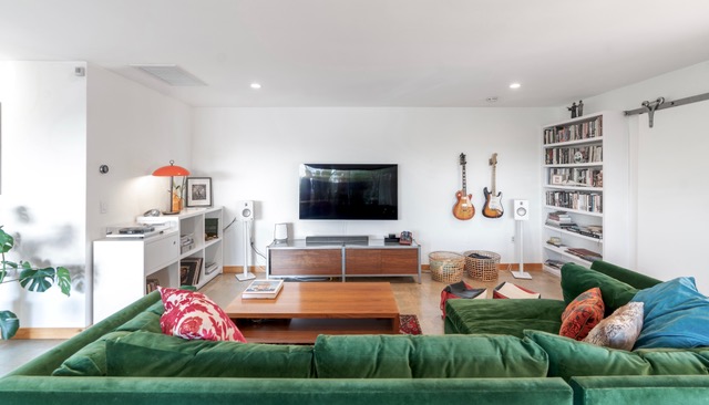 green furniture with tv and hanging guitars